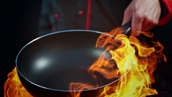 Super Slow Motion Shot of Chef Holding Empty Frying Pan and Flames at 1000Fps