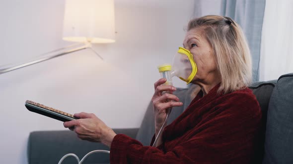 Vulnerable Old Woman in Quarantine Using Oxygen Inhaler and Changing Chanels on Tv