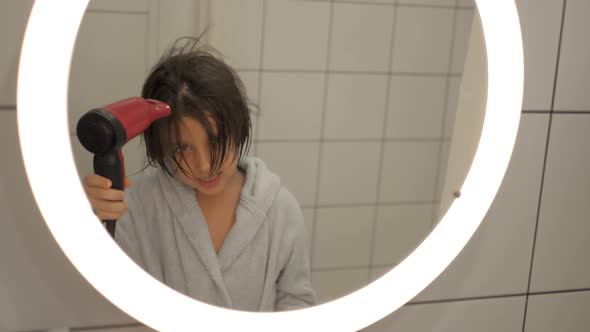 Caucasian Boy Child of Five Years Old in a Blue Bathrobe Brunette with Long Hair Drying His Head