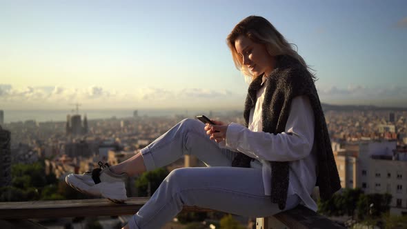 Happy woman writing text message on smartphone