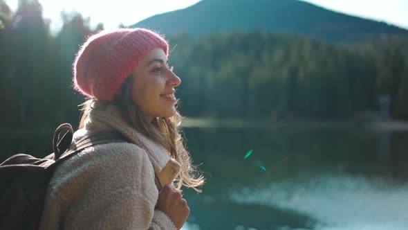 Slow Motion Inspired Joyful Woman Hiker Sits on Wooden Pier at Beautiful Mountain Lake with