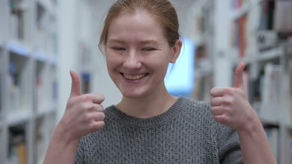 Thumbs Up By Young Woman in Cafe