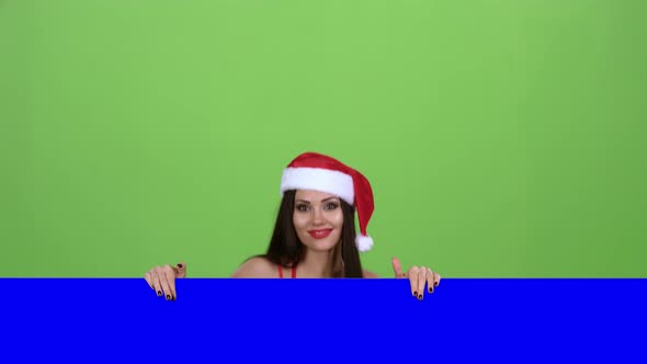 Santa Woman Peeking Out From Behind a Blue Board. Green Screen