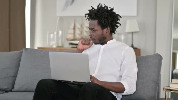 Sick African Man with Laptop Coughing at Home 