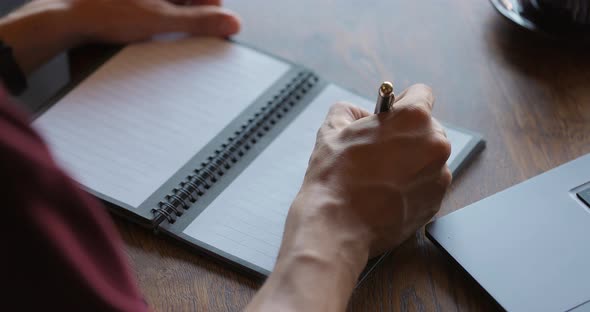 Unknown Man Writing Notes in His Paper Notebook with Ballpen