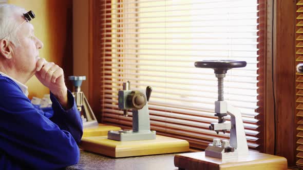 Horologist sitting and smiling in the workshop