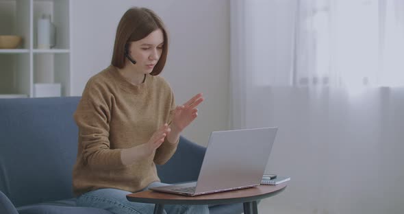 Woman Is Communicating Online, Using Laptop with Internet and Headphones with Microphone, Online