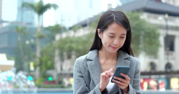 Asian Woman use of cellphone in city