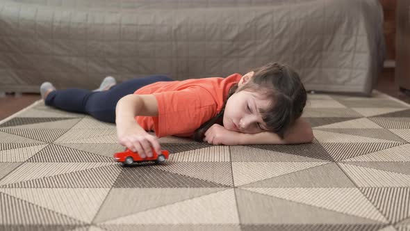 Girl with car on floor.