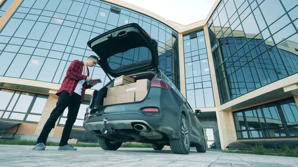 Delivery Man Is Checking and Unloading Parcels