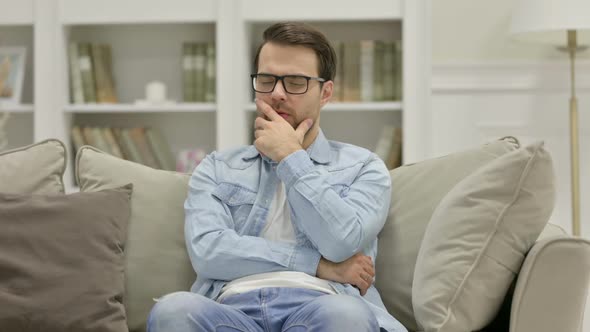 Young Man Sitting and Thinking at Home