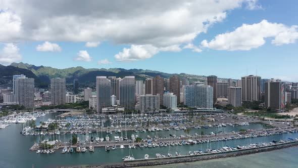 Aerial reverse pullback shot of a yacht marina in downtown Honolulu, Hawaii. 4K