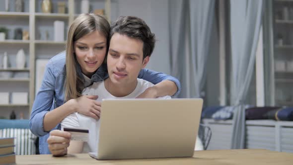 Successful Online Shopping By Young Couple on Laptop Via Credit Card