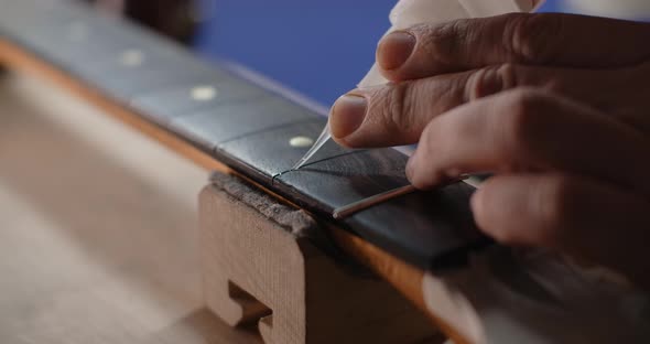 Luthier Adds Glue to the Fretboard Before Pressing in the New Guitar Frets