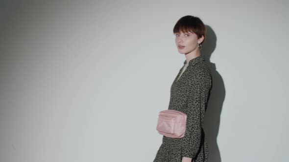 Cheerful Girl Walking in Studio and Posing with Shopping Bags