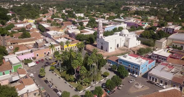 Beautiful significant historic temple in Cosalá village, Mexico. Small colorful houses and park, sun