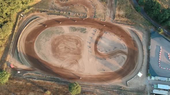Motocross running on a circular dirt track, top down aerial drone footage