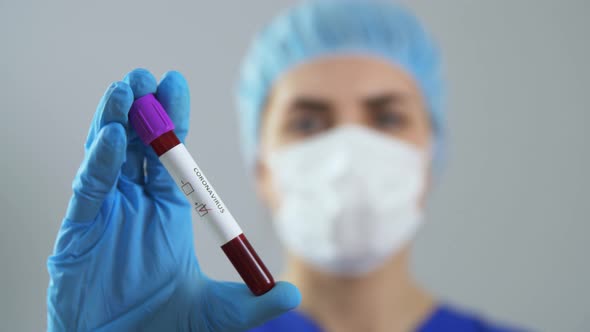 Doctor Holding Beaker with Coronavirus Blood Test