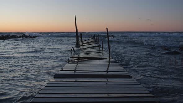 Storm Waves Old Wooden Jetty Fishing Boat Dock Floating on Sea at Sunset