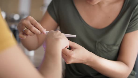 Tracking video of happy woman doing manicure. Shot with RED helium camera in 8K.