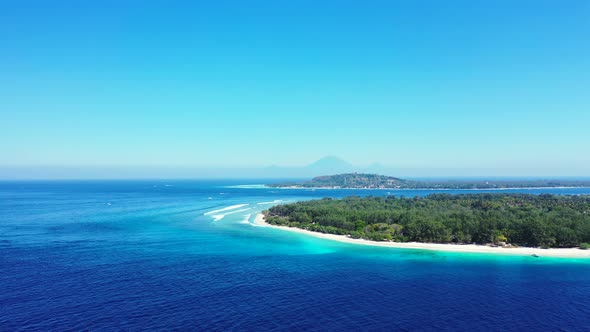 Daytime fly over tourism shot of a paradise sunny white sand beach and aqua turquoise water backgrou