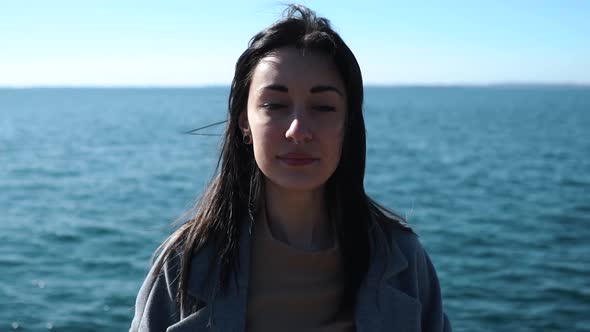 Slow motion shot of smiling woman with nose piercing at seafront