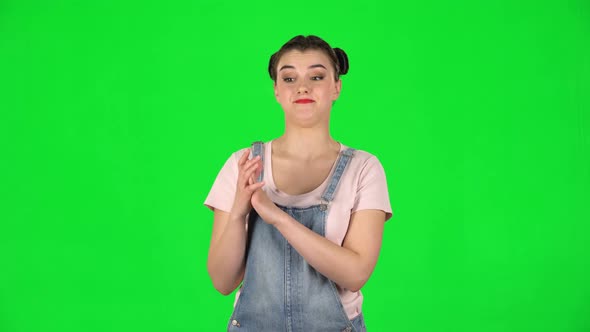 Girl with Two Hair-buns Claps Her Hands Indifferently on Green Screen