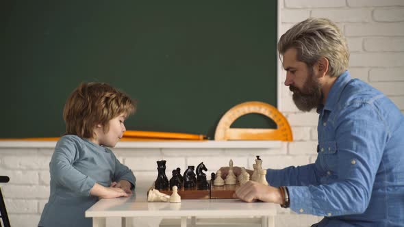 Father and Son Playing Chess Game. Little Clever Boy Thinking About Chess. Games and Activities for