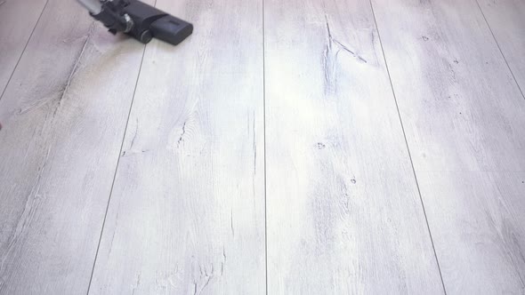 Man Vacuuming Gray Laminate Floor at Home