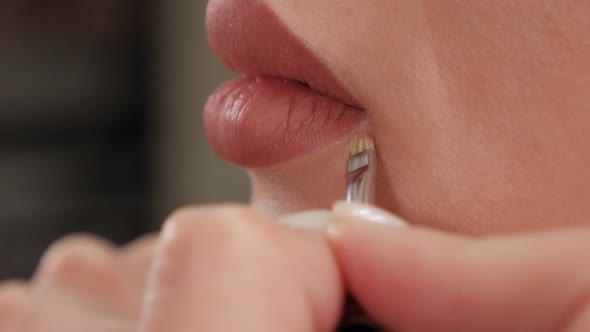 Closeup of a Cosmetologist Painting Lips with a Pencil Before Permanent Makeup