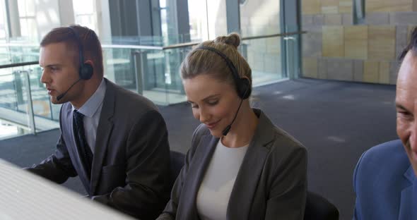 Young business people wearing headsets in a modern office