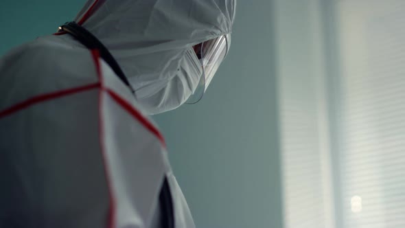 Portrait Doctor Holding Tablet Computer in Medical Protective Suit Hospital Ward