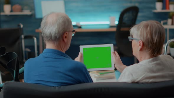 Aged Couple with Chronic Disability Using Green Screen on Digital Tablet