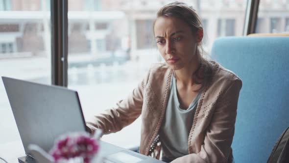 Businesswoman Dressed Casual Sitting in Cafe and Using Laptop.