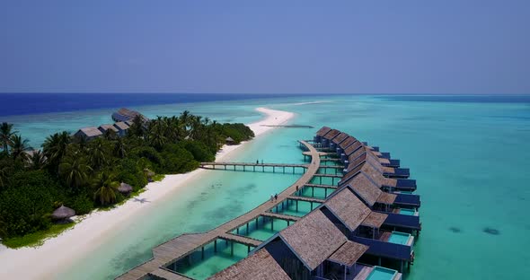 Luxury flying copy space shot of a white sandy paradise beach and aqua blue water background in colo