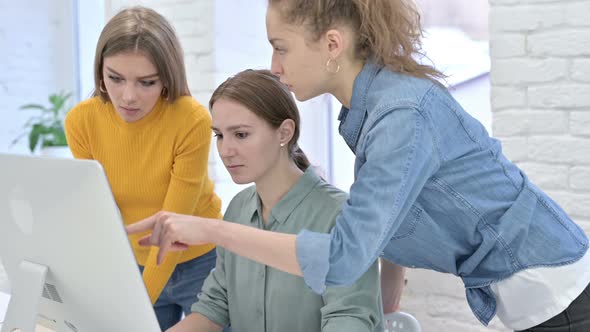 Creative Female Designers Discussing and Working on Desktop