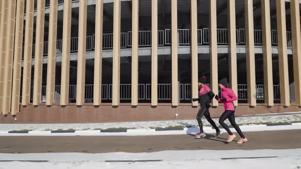 Fit People Jogging Against Rounded Building