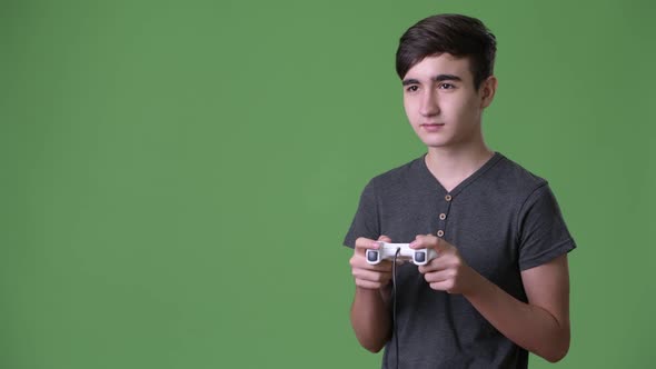 Young Handsome Iranian Teenage Boy Against Green Background