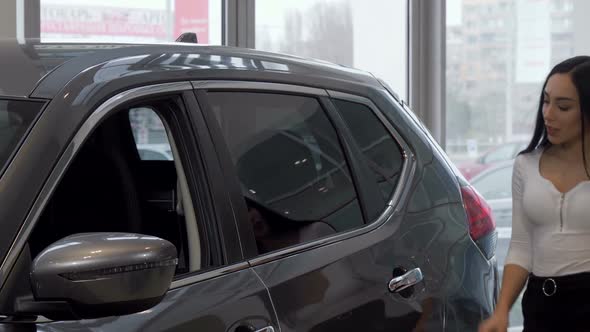 Beauitful Woman Choosing New Car at the Dealership