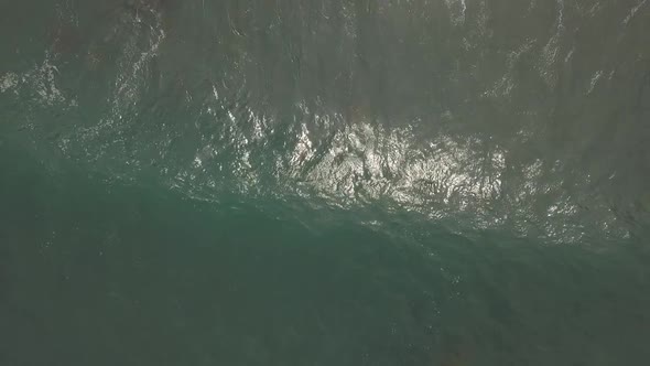 Drone shot of the ocean clashing against cliffs and rocky beaches in Galicia, Spain