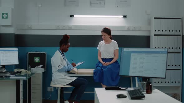 Young Patient on Bed Talking to Doctor for Annual Checkup Visit