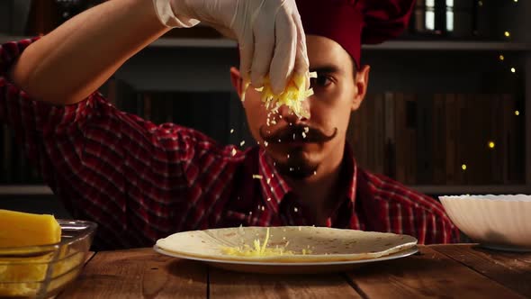 A Chef in a Red Toque Sprinkles Grated Cheese on Tortilla in Process of Cooking Enchilada in Slowmo