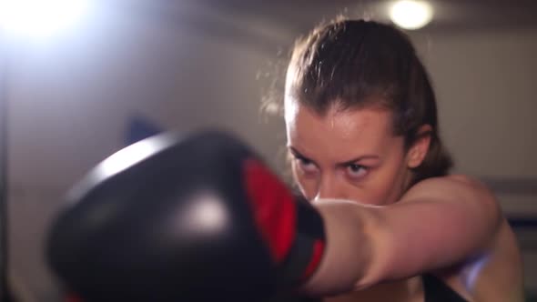 Beautiful Woman with Boxer Trains Punches in the Ring