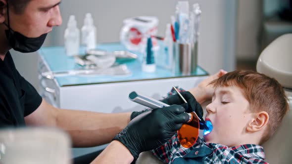 A Little Boy Having His Teeth Done - Putting the Photopolymer Lamp in the Mouth and Turning the