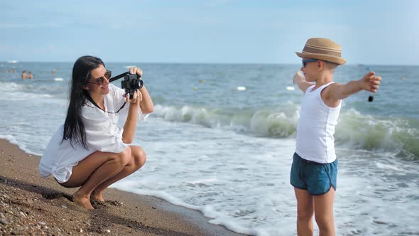 Travel Happy Mother Photographing Little Cute Son Near Sea Wave Using Camera Full Shot