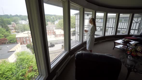 Caucasian, mature woman wearing a robe enters a spa’s tranquility room to rest and relax after her s