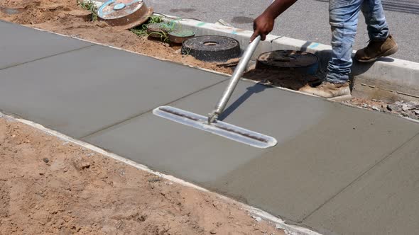 Laying Down a New Sidewalk in Wet Concrete on Freshly Poured Sidewalks