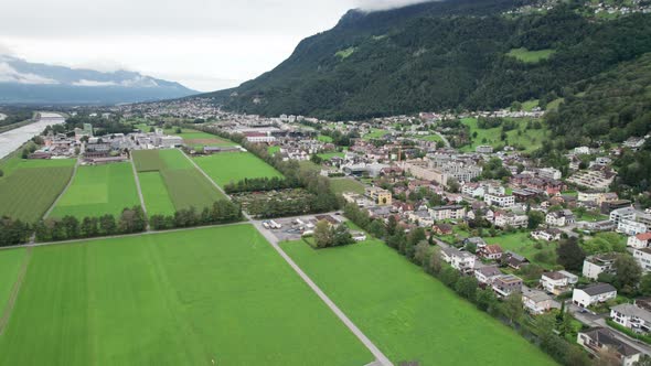 Liechtenstein with Houses on Green Fields in Alps Mountain Valley Aerial View