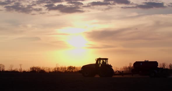 Stunning Sunset on the Horizon of a Tractor Tilling the Fields Agriculture