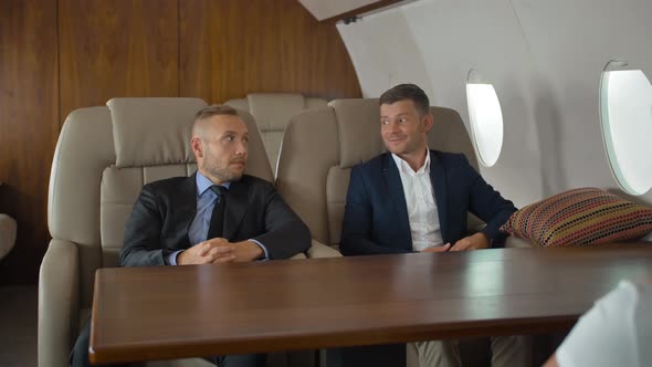 Businesspeople Discussing Inside Business Private Jet Armchairs